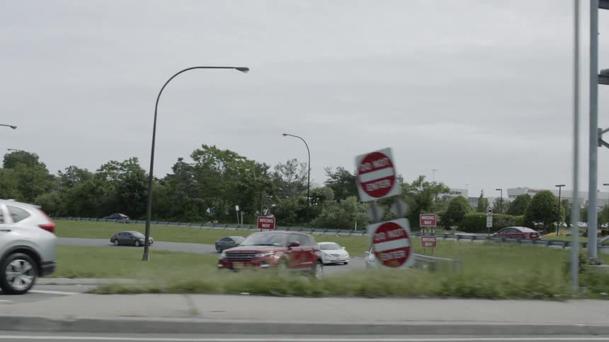 Cars driving off an exit ramp during the day