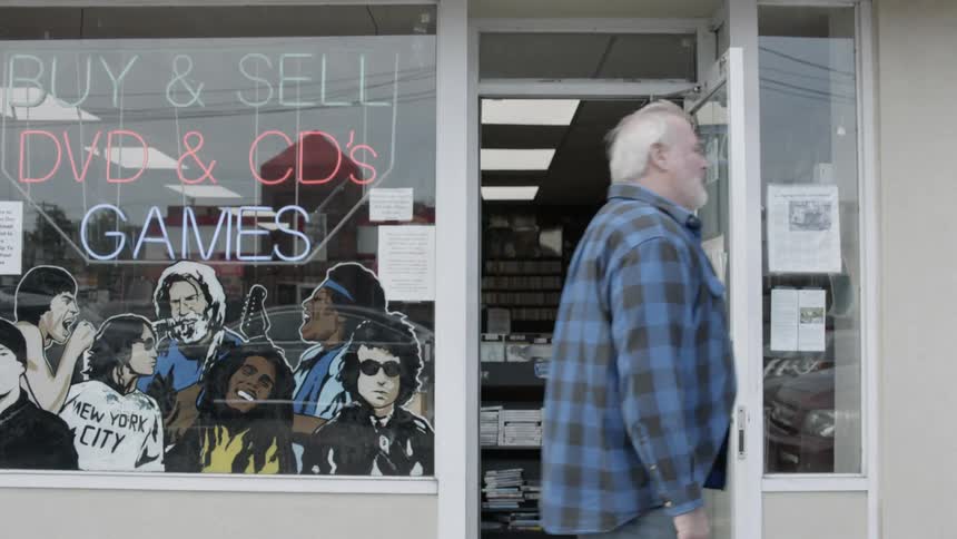A man walks in front of a music store