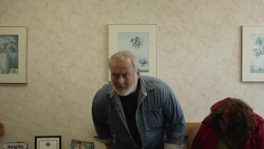 A man and a woman sit in a waiting room