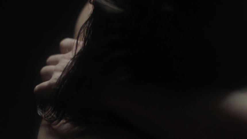 The man reaches to rub his back