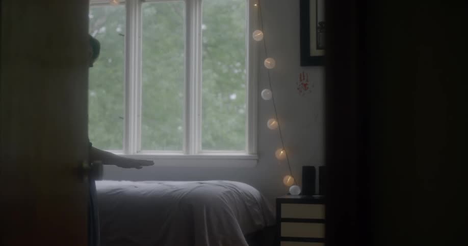 A woman walks in a bedroom