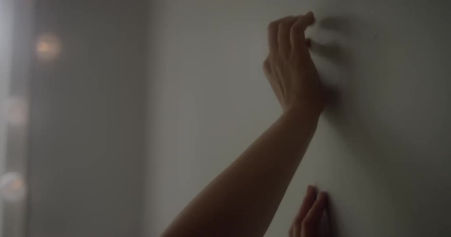 A woman rests her hands on a white well