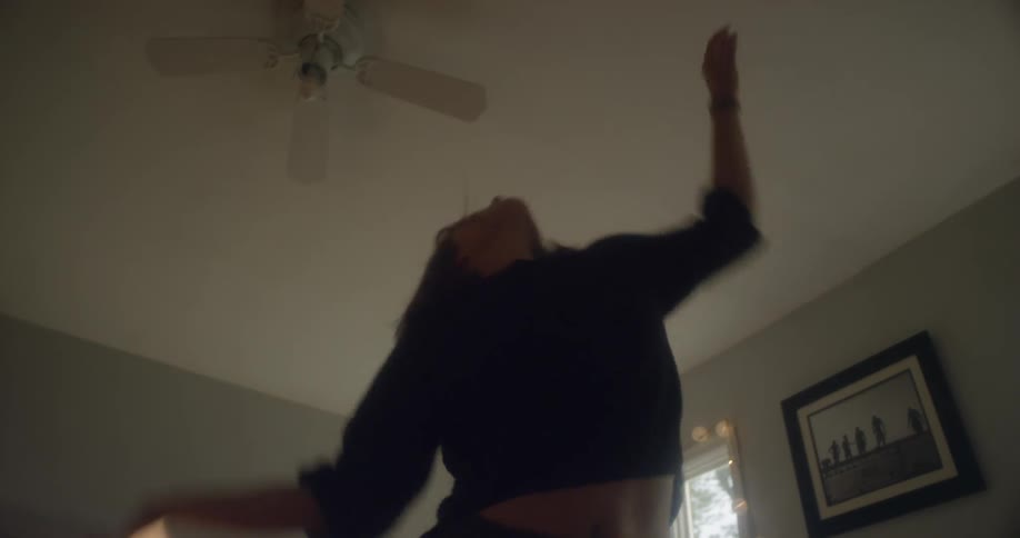 A woman stands in a room dancing