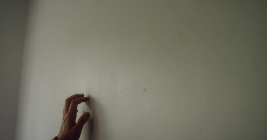 Woman's hand crawls up wall