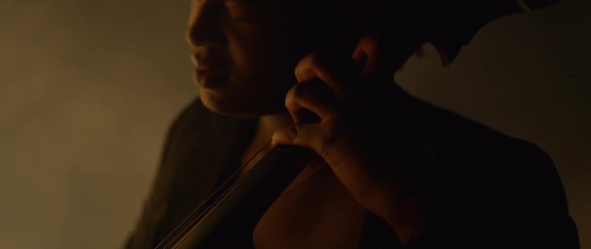 A woman plays the double bass in a foggy area