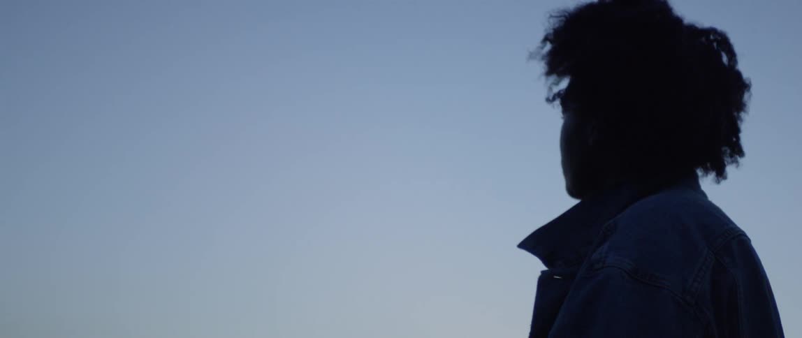 A woman walks outside at dusk