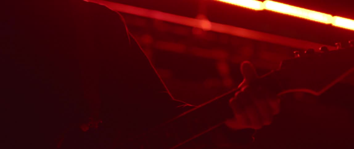 The person walks in the dark room with red lights