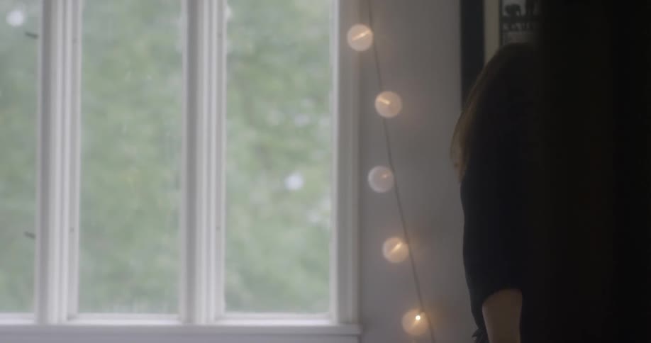 A woman is twirling around by the window