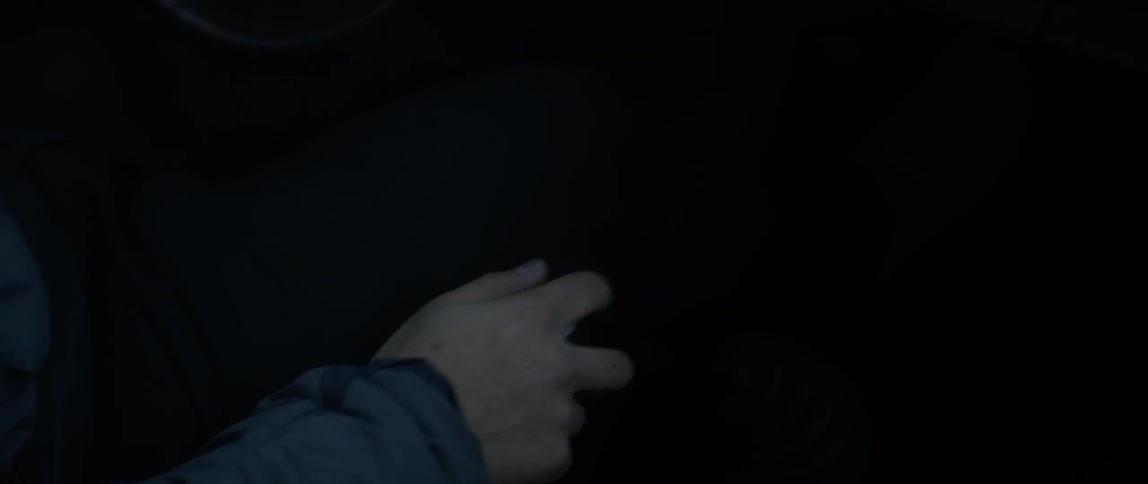 A driver shifts gears in a car