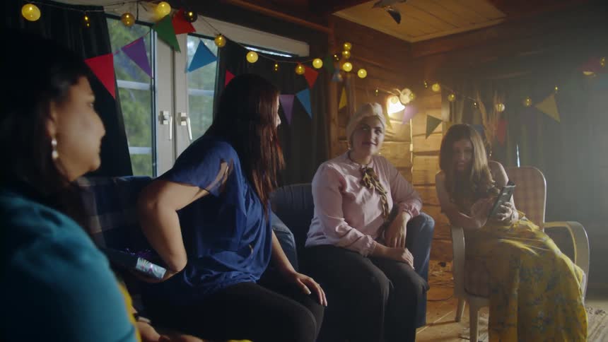A woman walks into a room with other women and surprises her with a gift