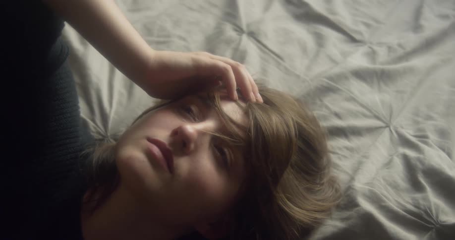 The woman rolls around in bed