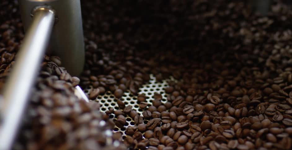 Coffee beans being stirred in a roaster