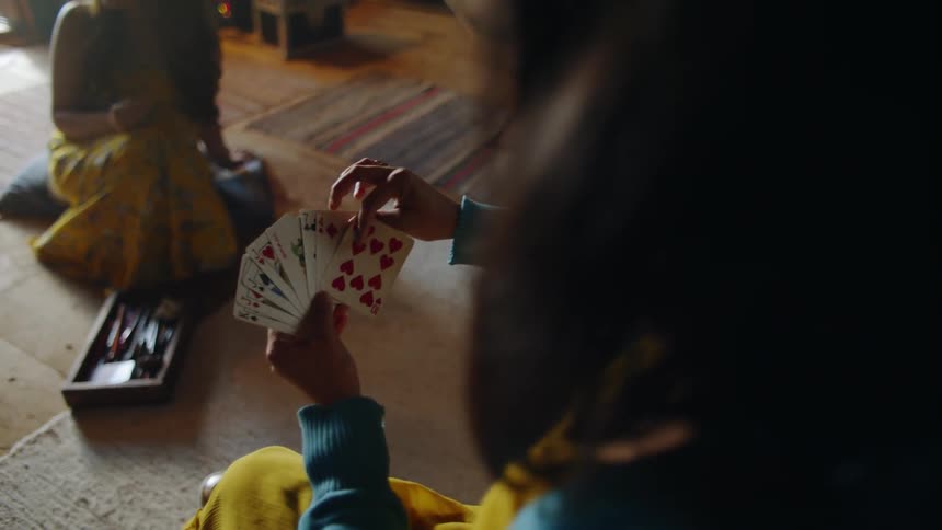 A woman plays cards in a living room