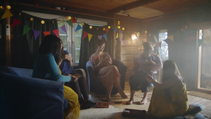 The family sit together playing cards and talking together