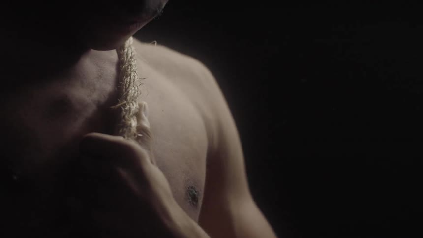 The man is moving a rope around his torso