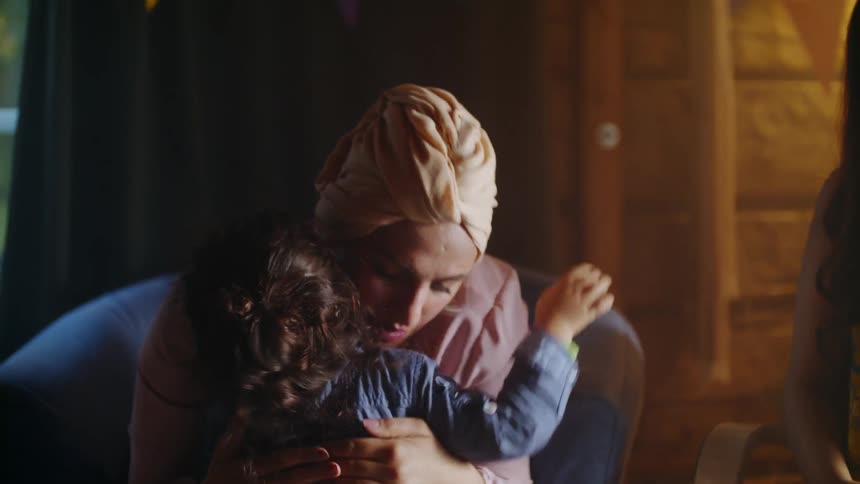 A woman smiles and embraces a small child