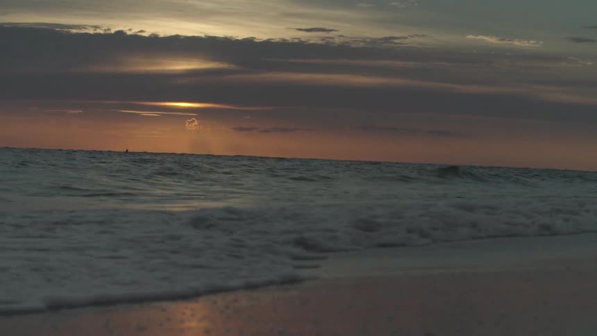 View of a wavy beach during dusk time