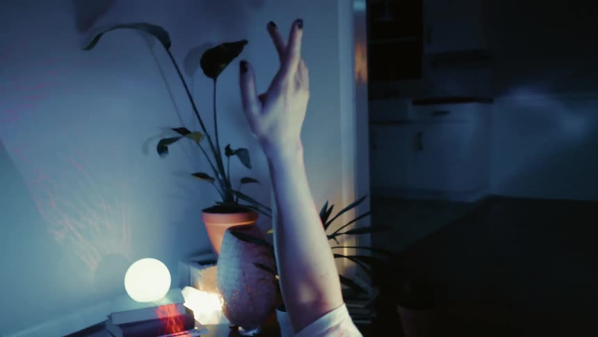 Lights shine around a woman lying in bed