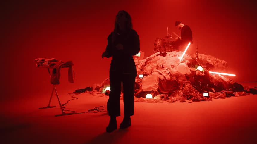 Man Playing On Pile Of Clothes In Studio