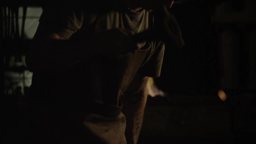 Sparks fly around a blacksmith at work