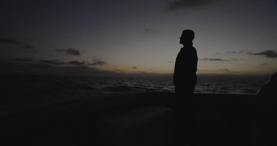 Man stands outside on the beach in the evening