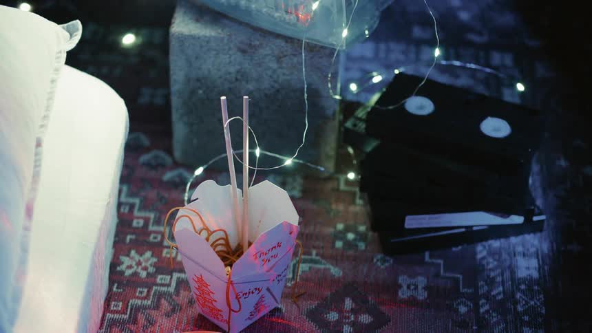 Box of chinese noodles lit up by a string of lights