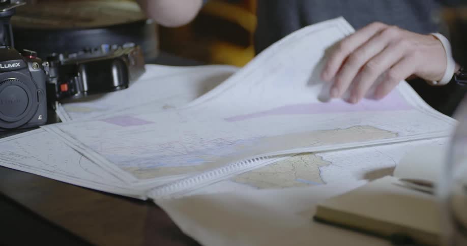 A man points at a map on a desk