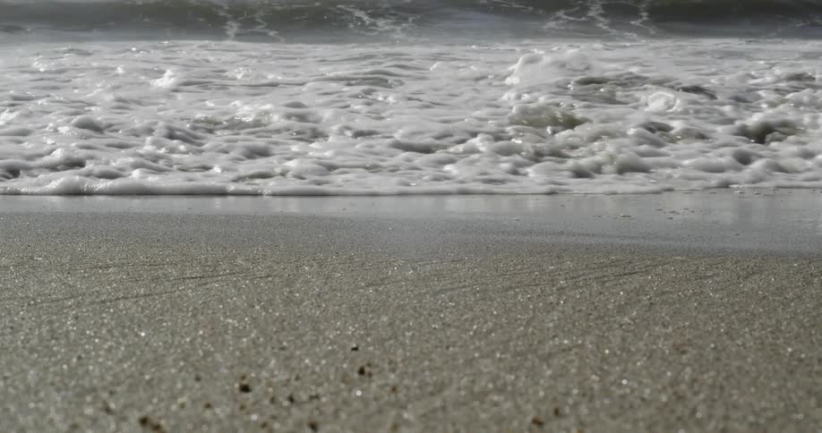 Ocean waves flow onto a sandy beach