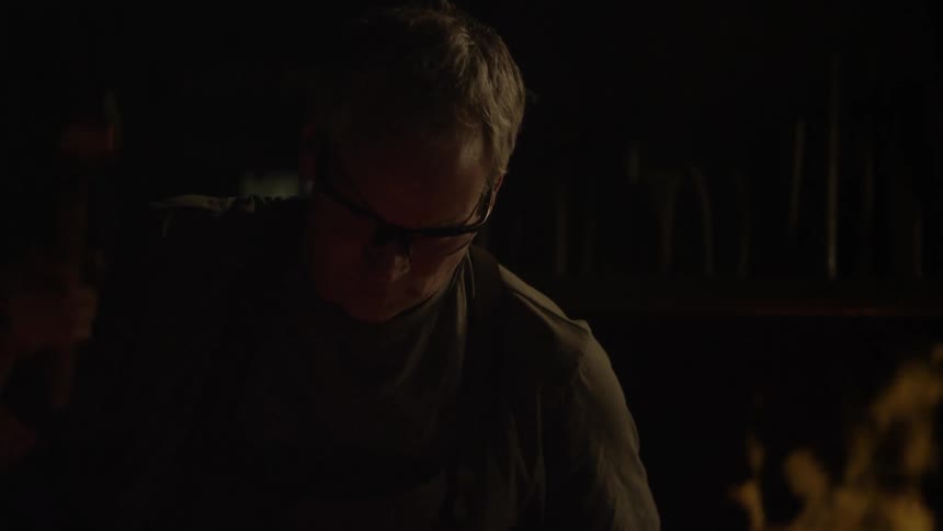 A blacksmith hammers next to a fire