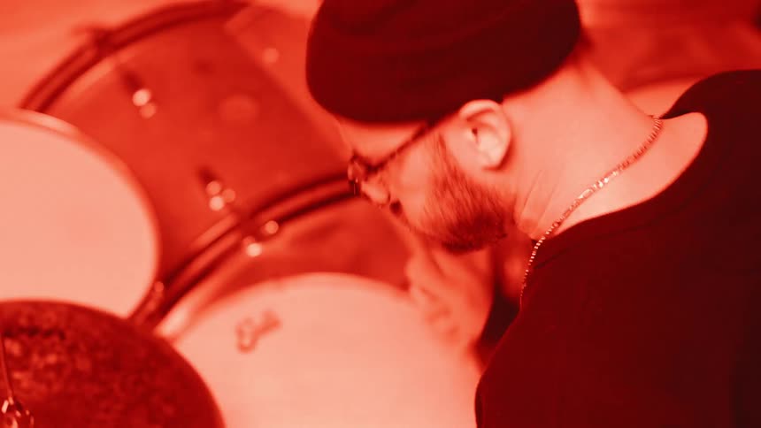 Lights flash while a man plays drums