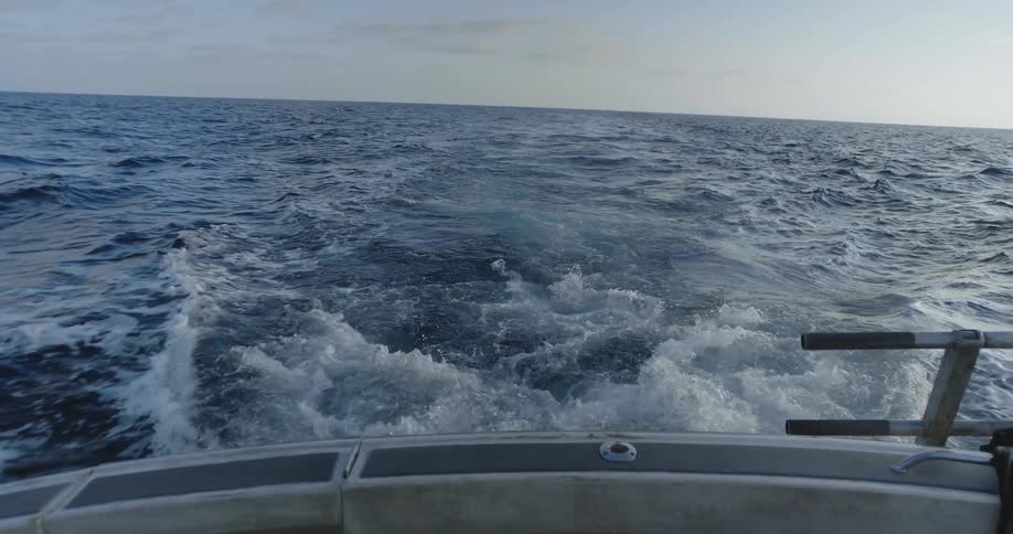 A boat traveling on the ocean at sunset