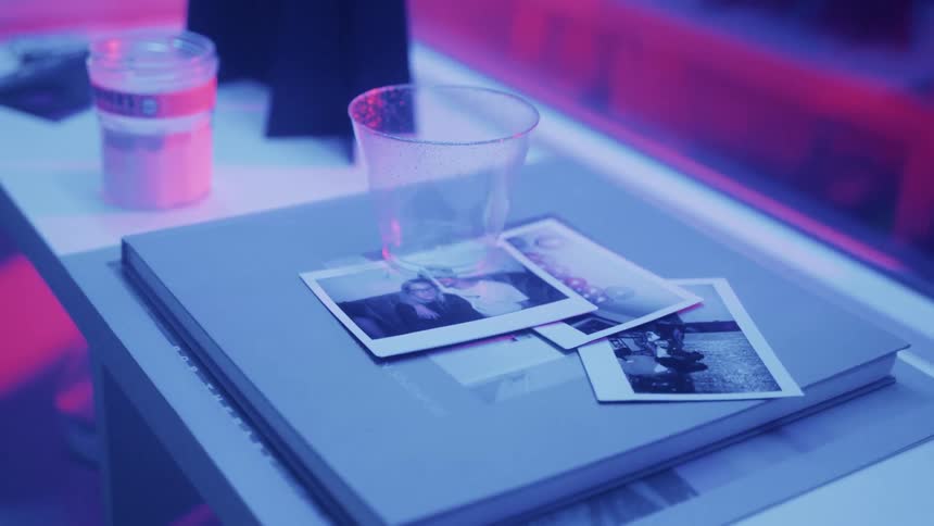 The table is covered with pictures and a glass