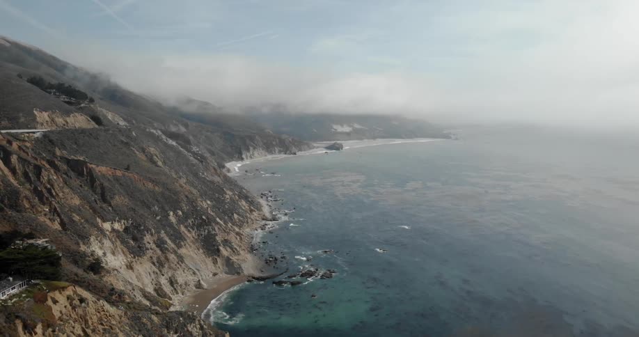 The waves crash against the mountain shore
