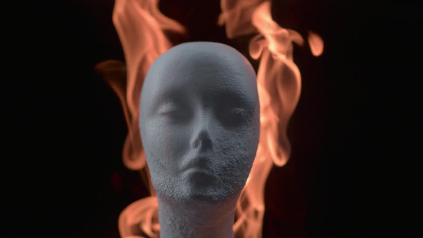 Flames around a human head statue