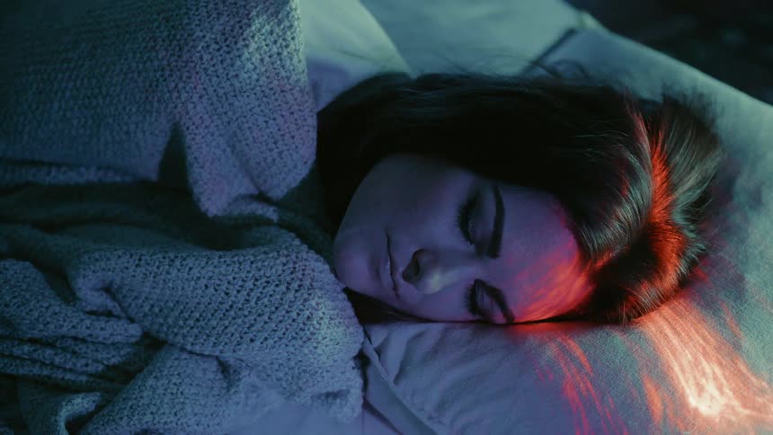 The woman slowly awakens in bed