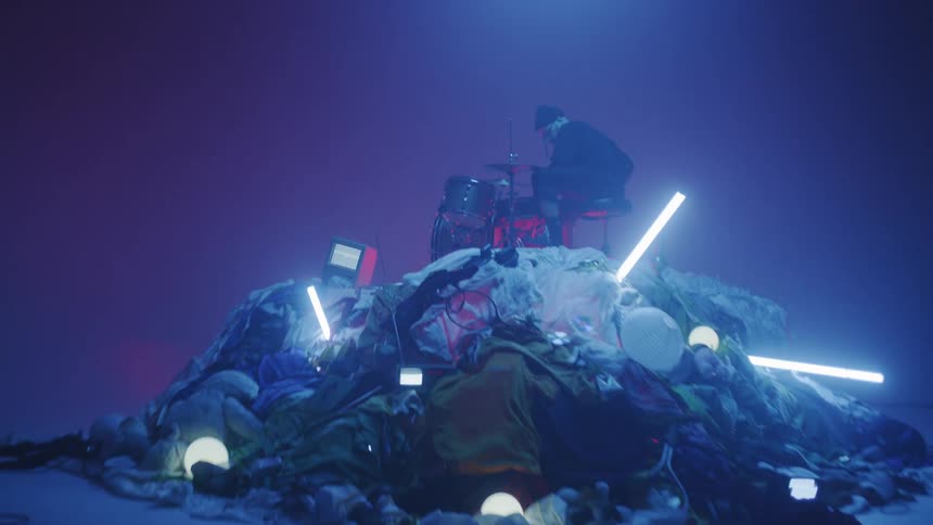Man Playing On Pile Of Clothes In Studio