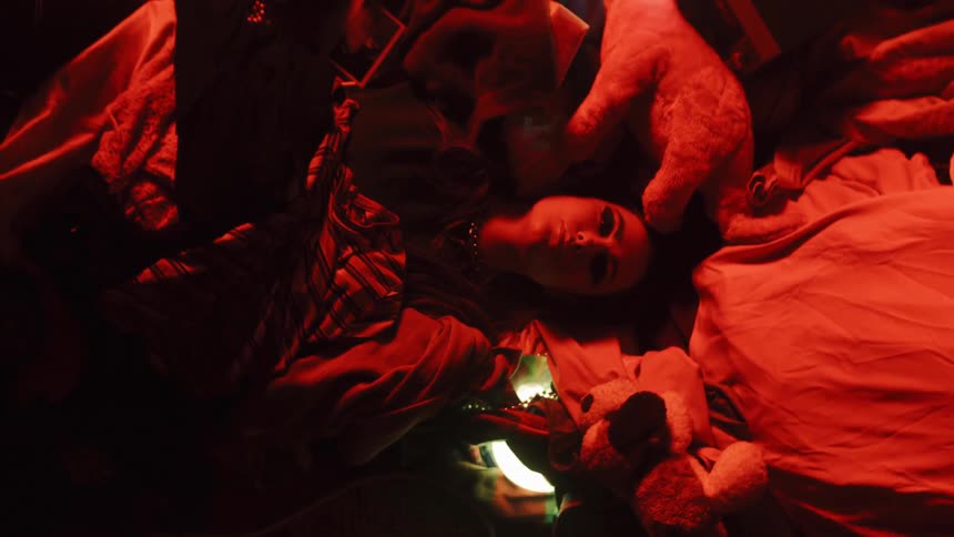 A woman rests on a pile of clothes