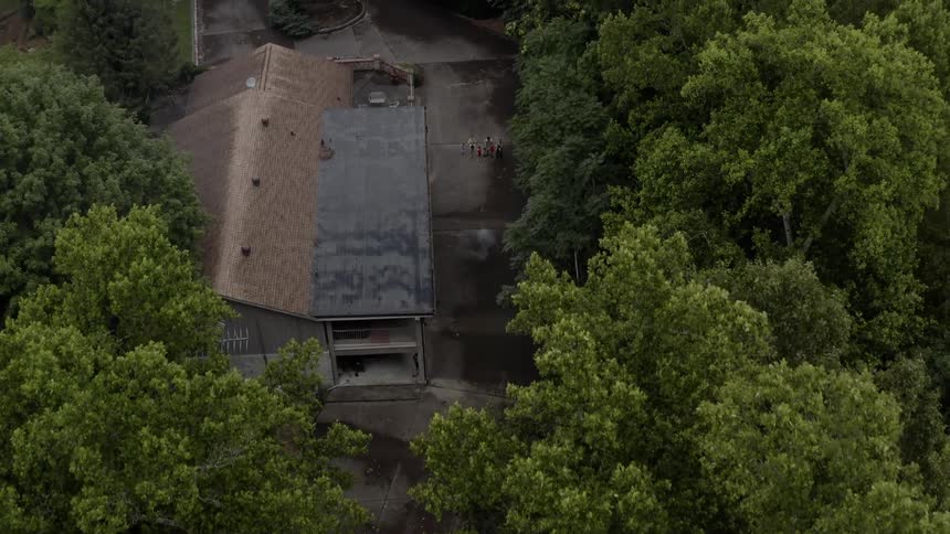 Trees partially cover a large building