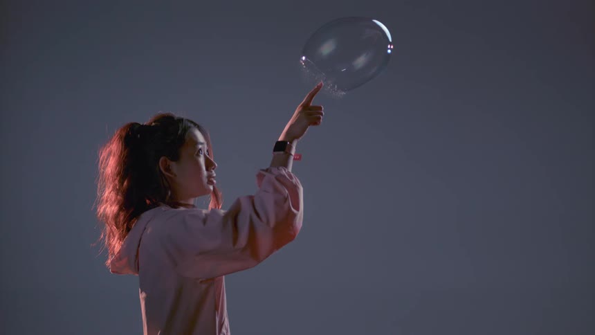 A woman pops a large bubble