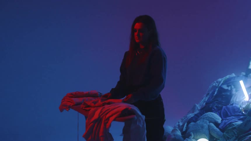Man Playing On Pile Of Clothes In Studio
