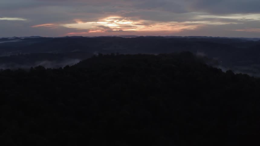 Sunset over trees and hills