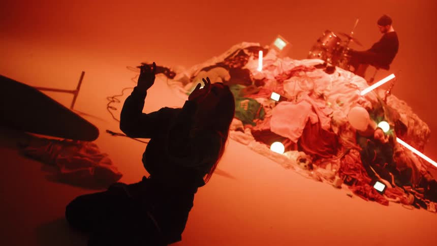 The woman kneels with her arms raised looking up