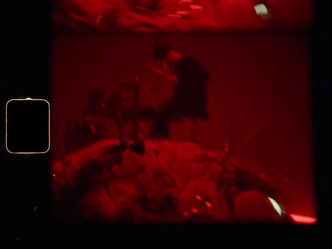 Lights flash while a drummer plays on top of a pile of random objects
