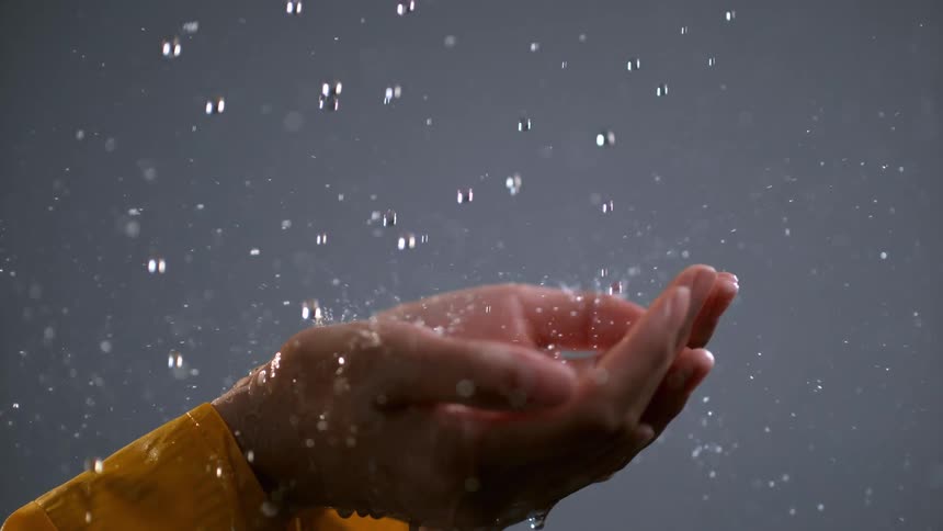 The water slowly falls on the person's hands