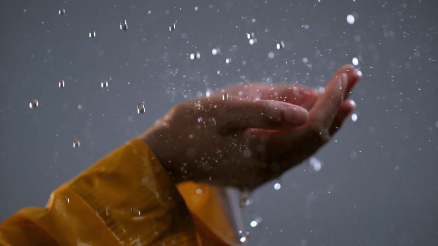 The rain drops in the person's hands