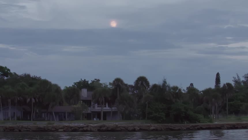 A scenery of an abandoned building near river at dawn
