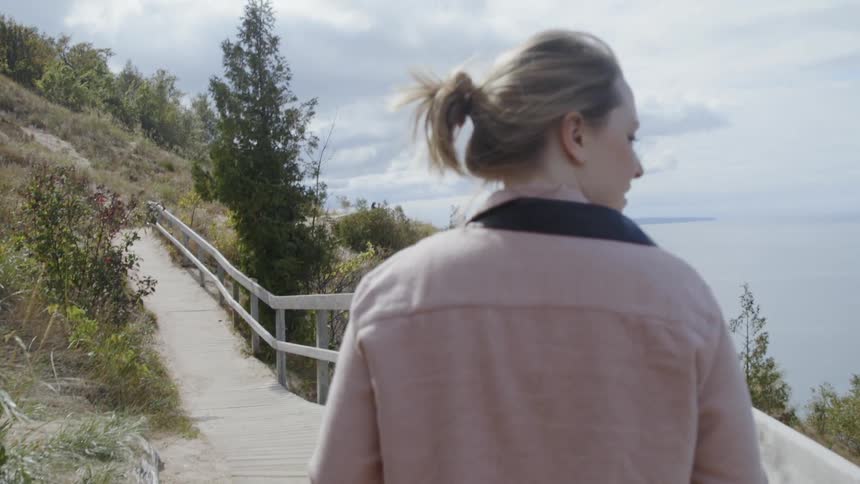 The woman is hiking near the water