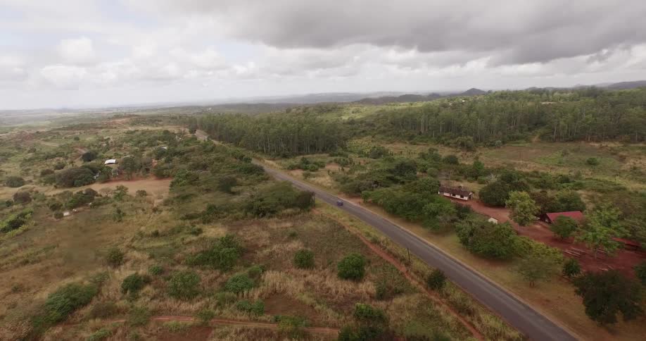 A vehicle drives down a rural road
