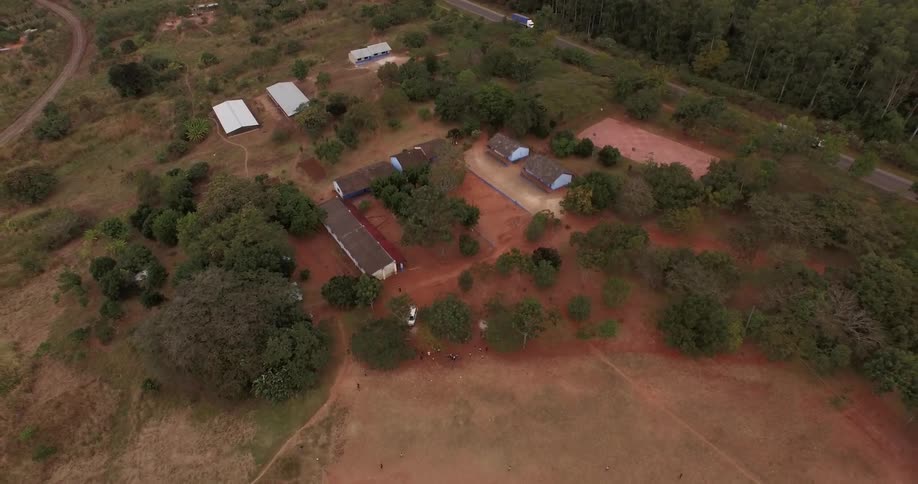 Aerial view of a ranch with a car driving down a nearby road