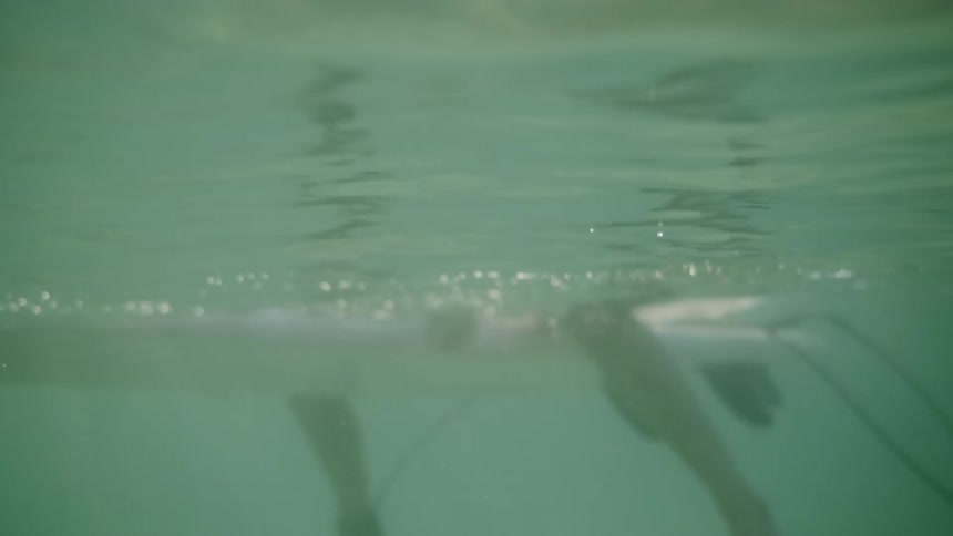 Woman sits on a surfboard as it floats in the water